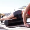 SPRI Black High Density Foam Roller 36" with model rolling their leg on it.