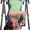Teeter Hang Ups FitSpine X1 Inversion Table with Model doing inverted torso rotation stretch.