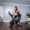 Inspire Fitness IC 1.5 Indoor Cycle with Model in living room.