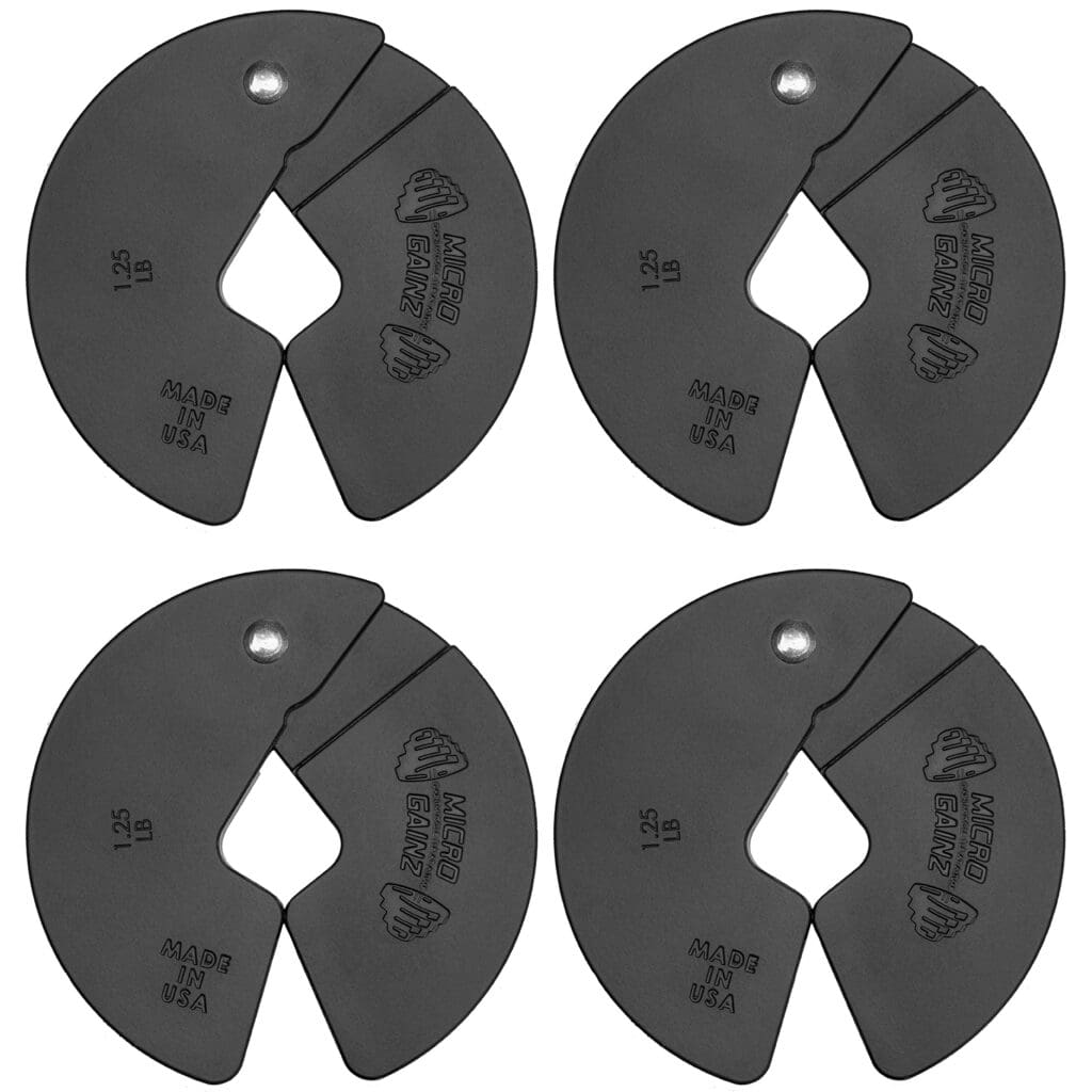 Set of four black magnetic micro weight plates with cutout designs, used for precise weight adjustments in strength training.