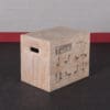 Wooden plyometric jump box with exercise illustrations on the side, used for jump and strength training in fitness routines.