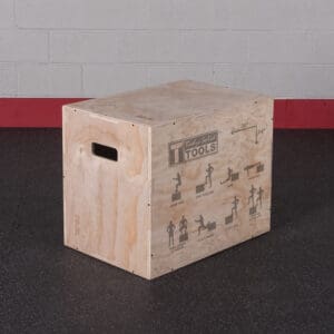 Wooden plyometric jump box with exercise illustrations on the side, used for jump and strength training in fitness routines.