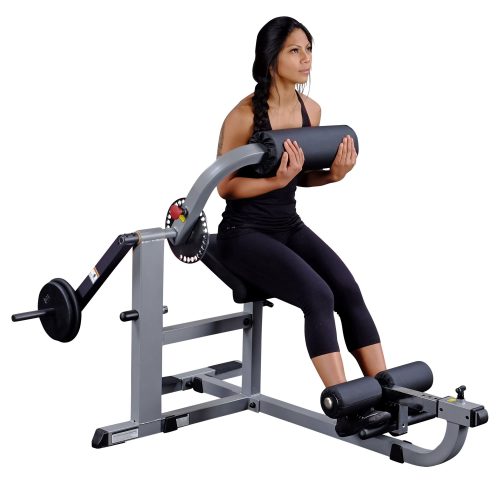 A woman in black workout attire uses a seated weight-loaded ab crunch machine, gripping the padded bar for a core exercise.
